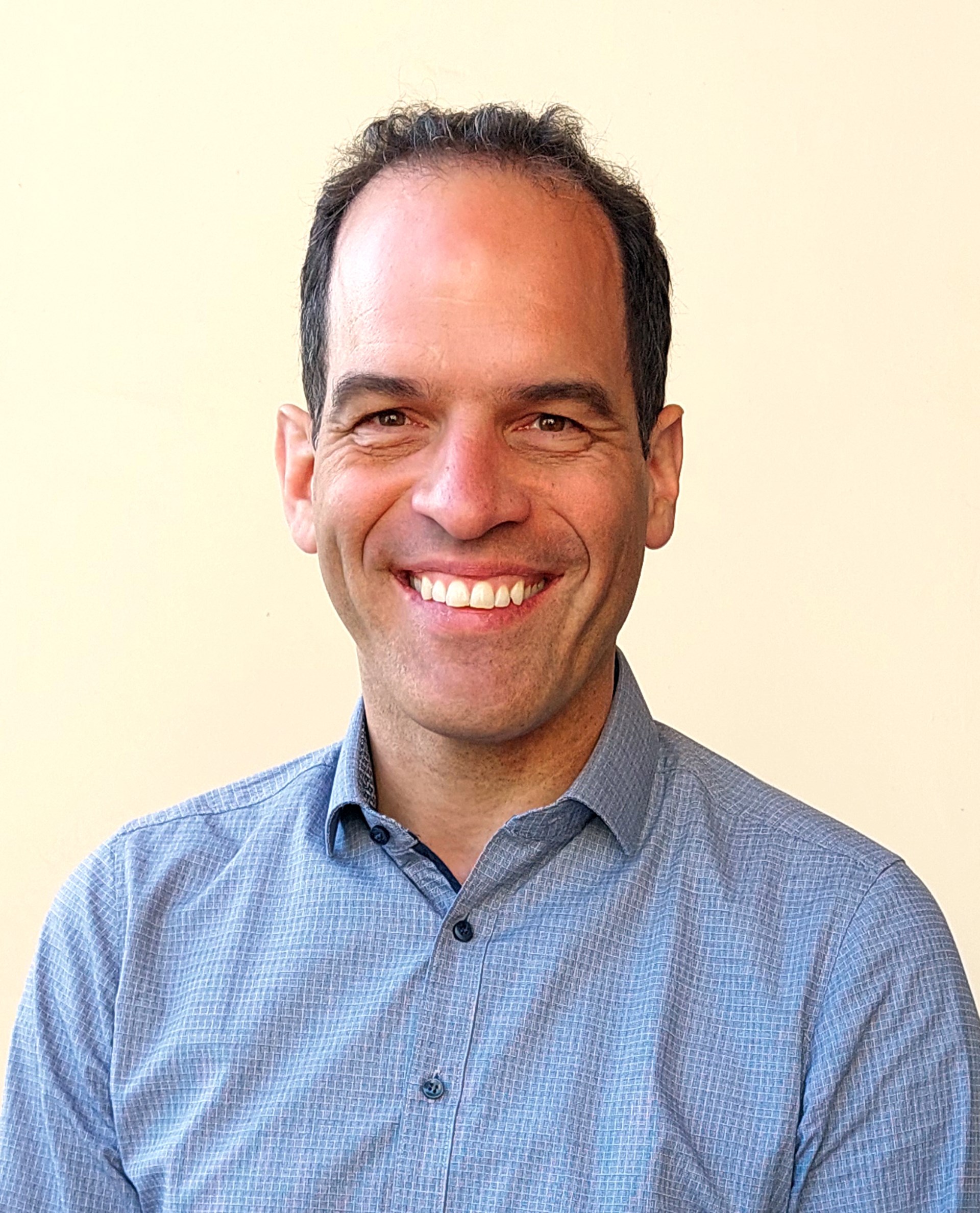 Porträtbild eines lächelnden Mannes im Karo-Hemd